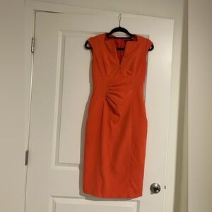 Orange Karen Millen bodycon midi dress with v neck and ruching.